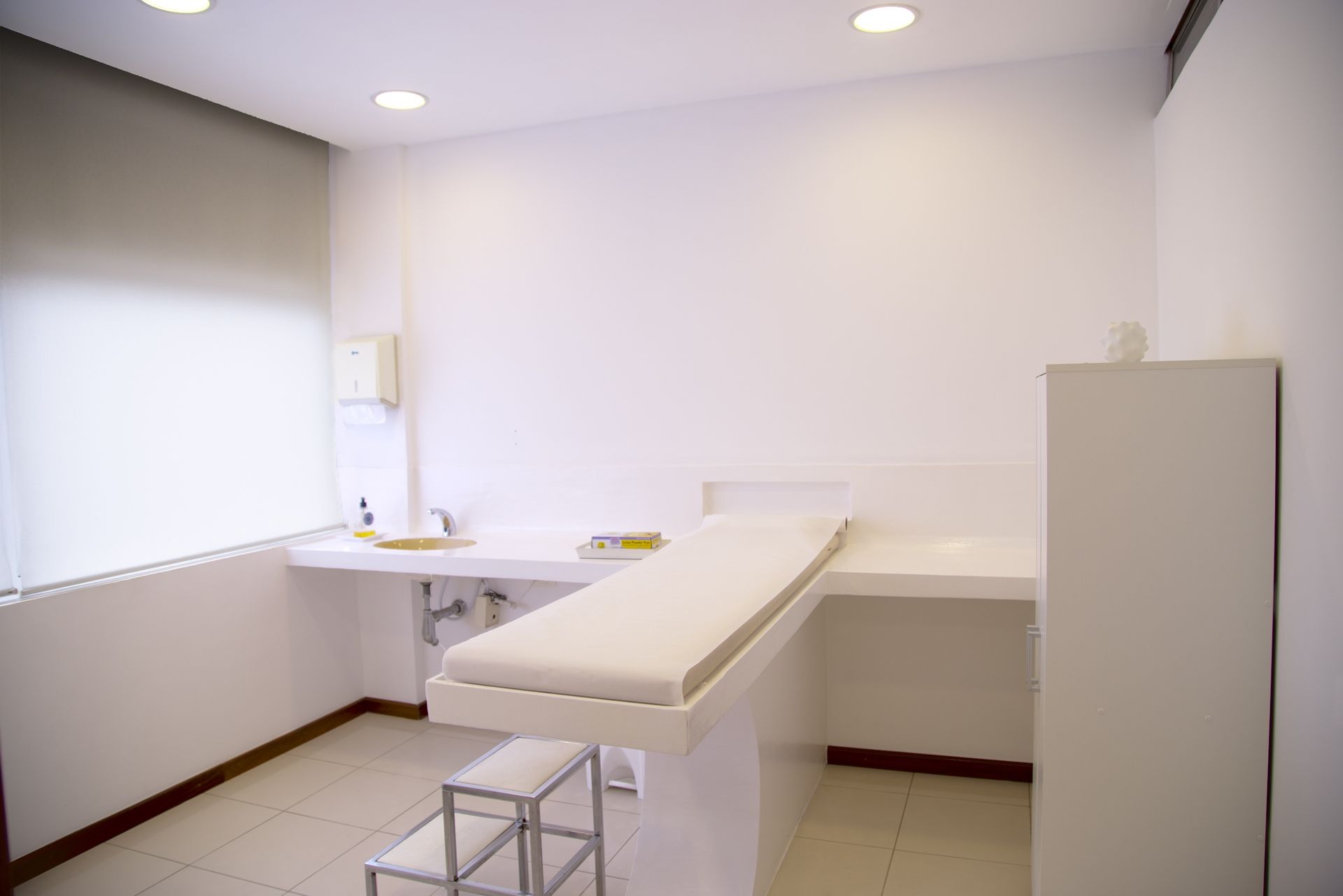 Bright clinic examination room with a treatment table